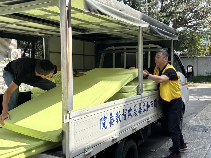 與志工協力搬運寢具上車